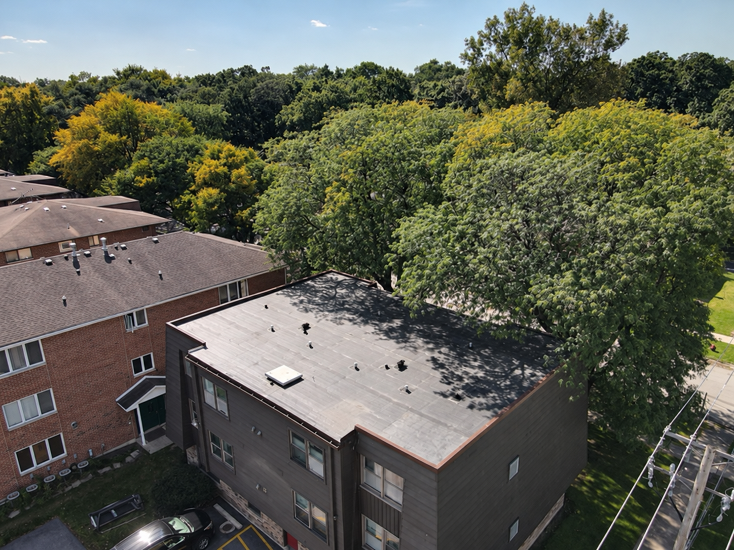 Angled aerial view of the Midlothian project roof beside neighboring buildings